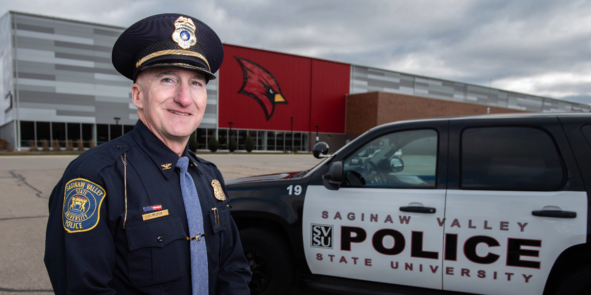 An officer standing next to car